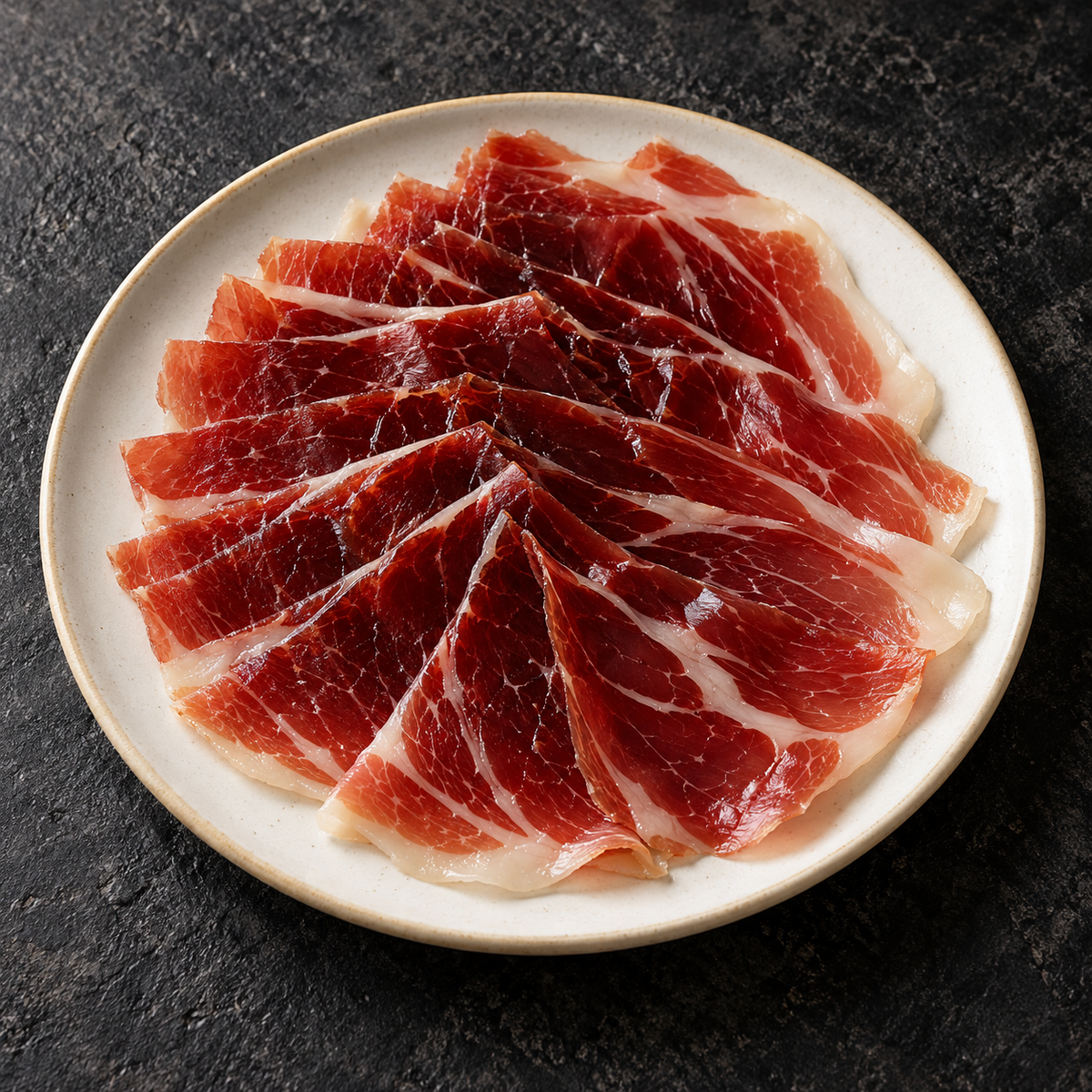 Suggestion de présentation illustrée : jambon Altanza Bellota 100% Ibérico, 80 g, servi sur une assiette.
