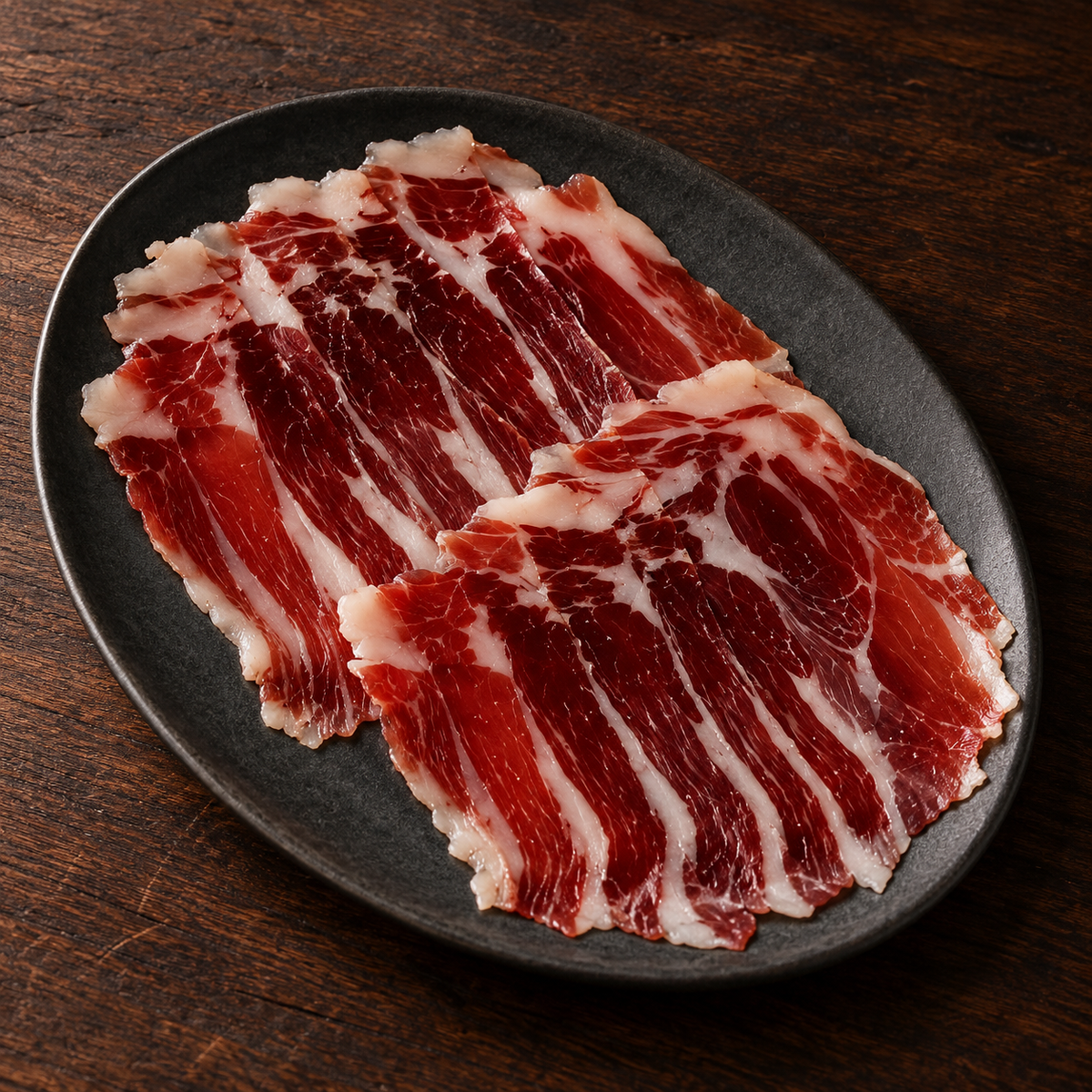 Ilustracyjna propozycja podania: łopatka Altanza Bellota 100% Ibérico, 80 g, na talerzu.