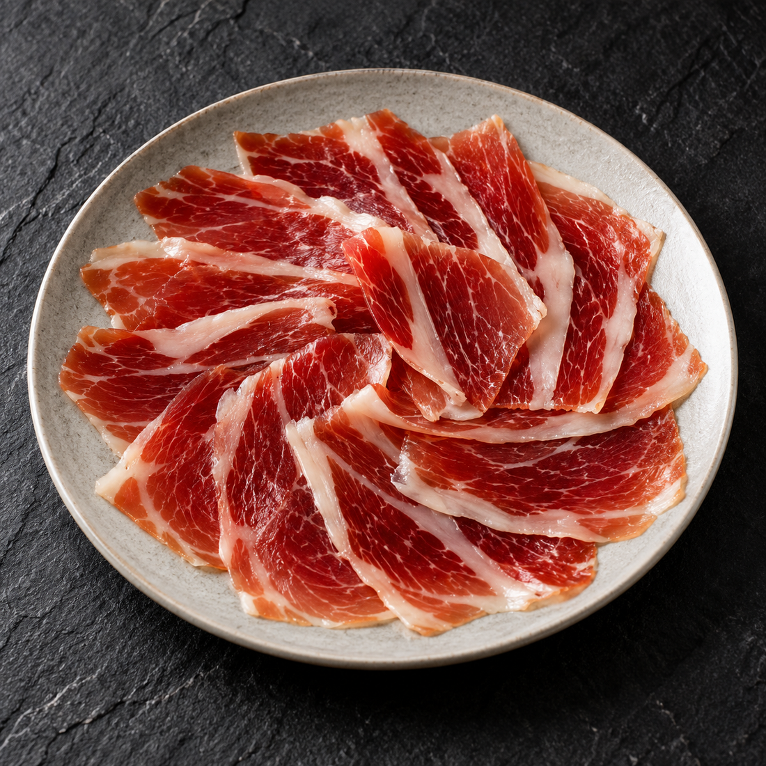 Illustrativt serveringsforslag: Altanza Cebo de Campo 50% Ibérico bovskinke, 80 g, anrettet på tallerken.