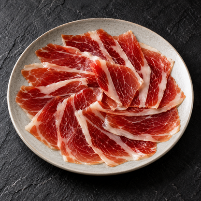 Ilustracyjna propozycja podania: łopatka Altanza Cebo de Campo 50% Ibérico, 80 g, na talerzu.