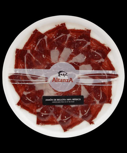 Den virkelige emballage til Altanza Bellota 100% Ibérico skinke på tallerken, 80 g, maskinskåret med knivskåret effekt.
